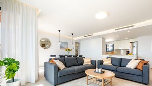A modern living room with two grey sofas, a round coffee table, and a large potted plant. - Penthouse Middle Views | Luxury private terrace pool, sea view (Fuengirola)