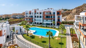 A modern hotel with a swimming pool, multiple balconies, and a landscaped garden. - Penthouse Middle Views | Luxury private terrace pool, sea view (Fuengirola)
