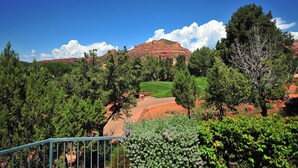 A golf course with a clear view of the green, surrounded by dense trees and a mountainous backdrop. - Sedona | Desert Golf Escape | Trails, Greens & Resort Pools (Sedona)
