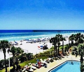 A beach resort with a pool, sun loungers, and a pier extending into the ocean. - OCEAN FRONT PROPERTY next to Pier Park with pools, tiki bars (Panama City)
