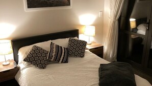 A neatly made bed with patterned pillows, a bedside lamp, and a framed picture on the wall. - Very modern, new, clean, 3 Bedroom home 2 bathroom (Tūrangi)