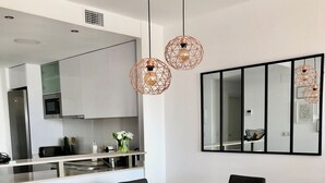 A modern dining area with a wooden table and grey upholstered chairs.