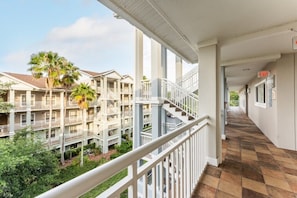 A multi-story hotel with balconies, a central staircase, and a checkered floor.