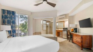 A hotel room with a large bed, a desk, a television, a bathroom, and a balcony. - Orlando | Friends Orlando Getaway | 3BR Sleeps 8 (Orlando)
