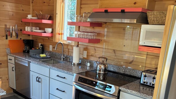 Una cocina moderna con paredes de madera, electrodomésticos de acero inoxidable y una ventana.