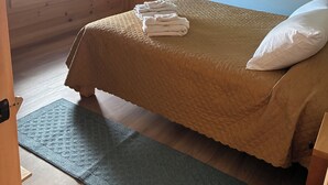 Un dormitorio con una cama, una puerta de madera, una ventana y un tapete verde.