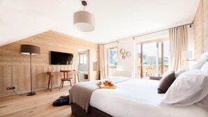 Ein modernes Hotelzimmer mit einem großen Bett, einem Schreibtisch und einem Fernseher.