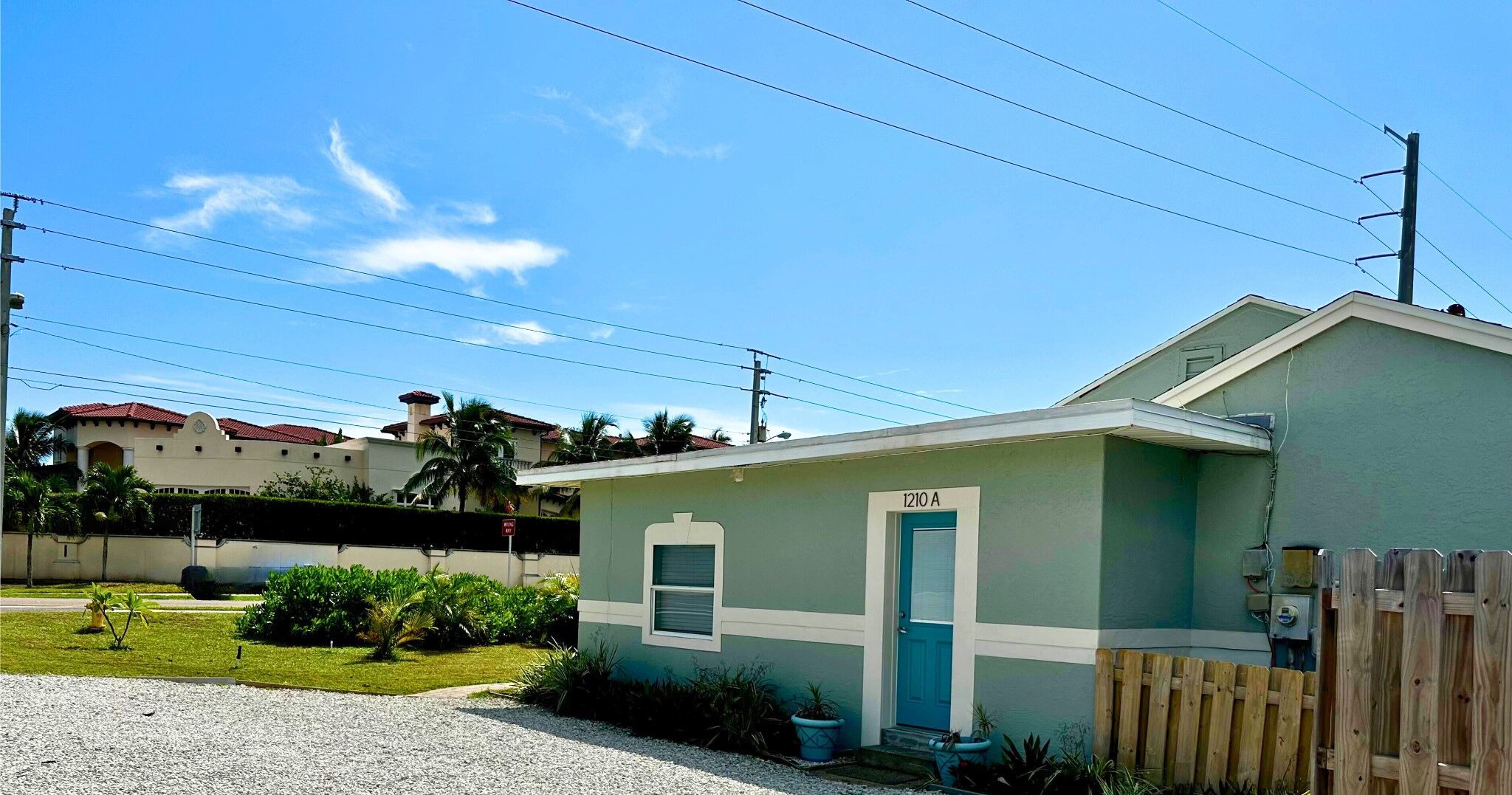 A small, single-story building with a blue door and the number 1210A on the side.