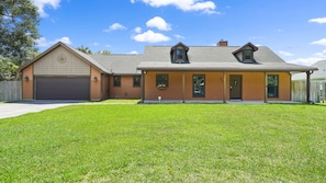 A two-story house with a garage, a front porch, and a well-maintained lawn.