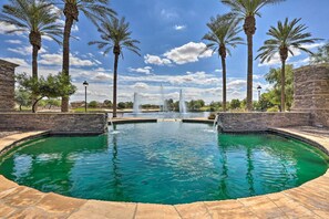 A swimming pool with a fountain, surrounded by palm trees and stone walls. - Updated Maricopa Retreat < 2 Miles to Golf! (Maricopa)
