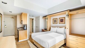 A hotel room with a bed, a desk, a wardrobe, and a bathroom.