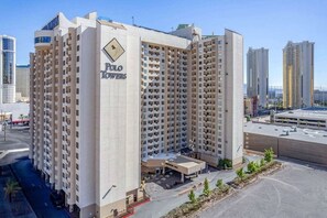 Um hotel moderno com um letreiro chamativo que diz 'POLO TOWERS'.