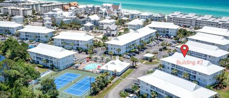 A resort with multiple buildings, a tennis court, and beach access.