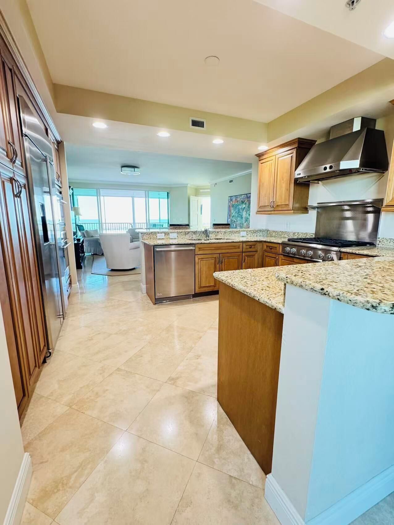 A spacious kitchen with granite countertops, stainless steel appliances, and a large island.