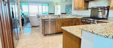 A spacious kitchen with granite countertops, stainless steel appliances, and a large island.