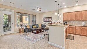 A modern kitchen with wooden cabinets, a central island, and pendant lighting. - Serenity Town House! Heated Pool, Gym! 2 King Beds! 1 Dog Friendly! (Chandler)