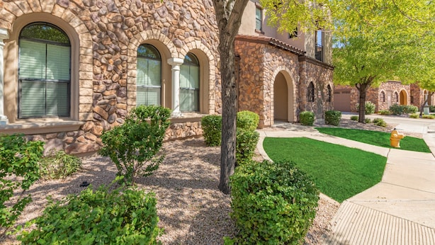 A stone building with arched windows and a well-maintained lawn. - Serenity Town House! Heated Pool, Gym! 2 King Beds! 1 Dog Friendly! (Chandler)