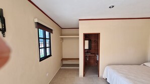 A hotel room with a bed, a window, a door leading to a bathroom, and a tiled floor. - Hotel La Piramide Izamal (Izamal)