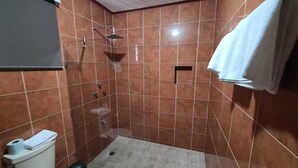 A small bathroom with a shower, toilet, and sink. - Hotel La Piramide Izamal (Izamal)