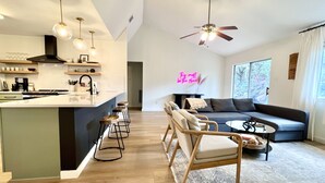A modern kitchen with a central island, bar stools, pendant lighting, and a ceiling fan. - Scenic views on a quiet fishing cove. Boat Slip, Kayaks, Peddle Boat, SUPs. (Sunrise Beach Village)