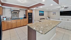 A modern kitchen with granite countertops, wooden cabinets, a built-in oven, and a large island. - Near Tesla's Building - Centralized location (St. Petersburg)