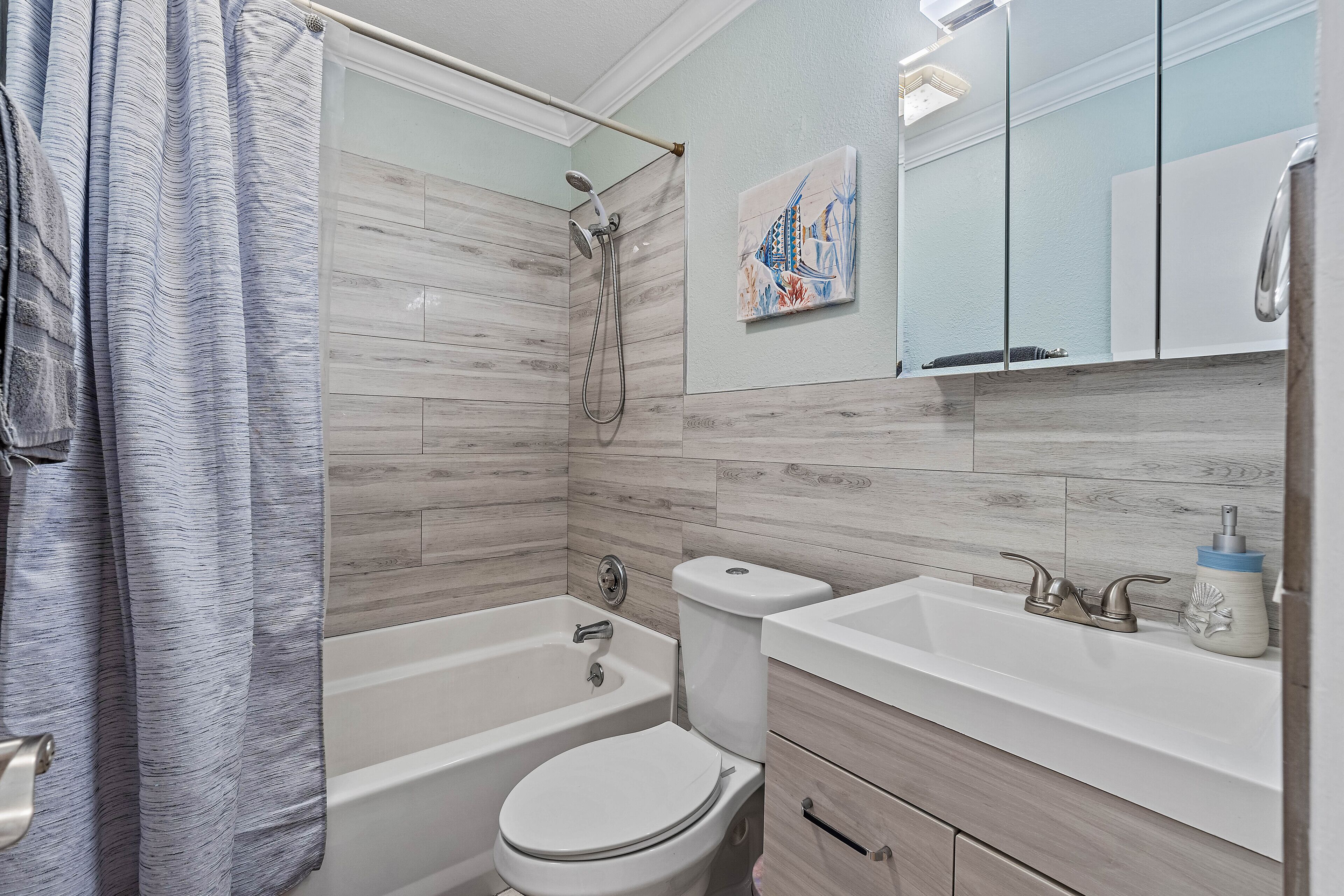 Ein modernes Badezimmer mit Badewanne, Toilette und Waschbecken.