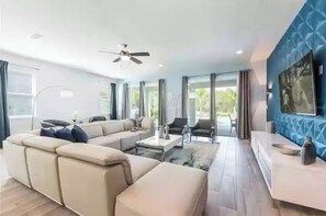 Relax in this spacious living room with a large L-shaped sofa, coffee table, and dining area.
