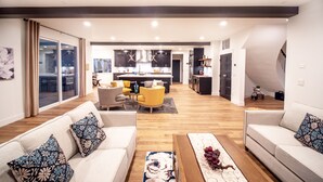 Un salon moderne avec un ensemble de canapés, une table basse et un coin repas à l’arrière-plan.
