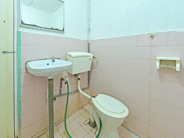 A small bathroom with a toilet, sink, and a mirror.