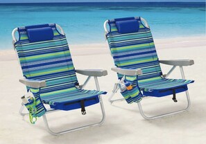 Relax in comfort with two beach chairs featuring backrests and armrests, complete with a convenient cup holder.