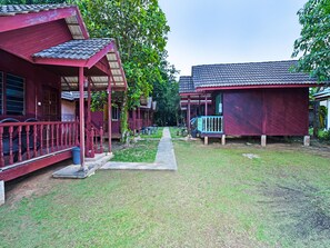 Traditional houses line a winding pathway amidst lush greenery.