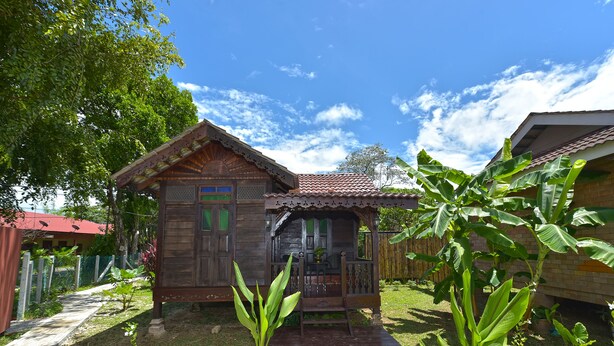 A wooden house with a porch and a small garden area. - Collection O 90622 Sehijau @ Cenang (Langkawi)