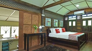 A bedroom with a wooden bed, a nightstand, a mirror, and a window with curtains. - Collection O 90622 Sehijau @ Cenang (Langkawi)