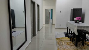 A modern kitchen with a dining area, a refrigerator, and a mirror. - OYO Homes 90611 Homestay D'emas (Kuala Lipis)