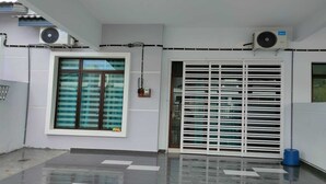 A modern building exterior with a large window, air conditioning units, and a metal gate. - OYO Homes 90611 Homestay D'emas (Kuala Lipis)