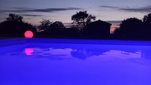 En swimmingpool med en solnedgång i bakgrunden.