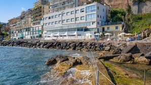 A coastal hotel with multiple floors, balconies, and a view of the sea. - La Perla del capo hotel (Ospedaletti)