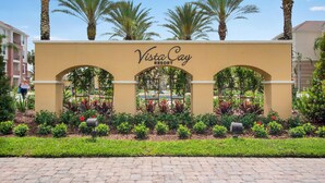 The entrance sign of Vista Cay Resort with a landscaped garden in front. - Cozy 3BR Apartment - Vista Cay Resort near Disney! (Orlando)