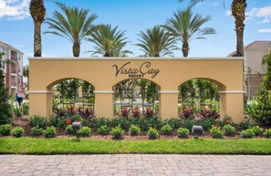 The entrance sign of Vista Cay Resort with a landscaped garden in front.