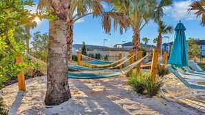 A beach area with hammocks, palm trees, and a sandy path. - Luxury Home with Private Pool in Davenport (Davenport)