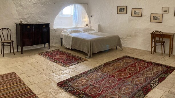 Een slaapkamer met een bed, een bureau, een stoel, een kledingkast en een raam.