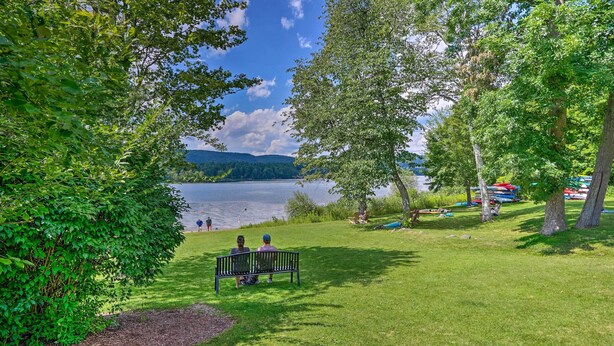 Ein Park mit einem See, Bänken und Booten.