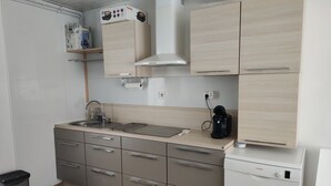 Una cocina compacta con un lavamanos, una cafetera y un lavavajillas Bosch.