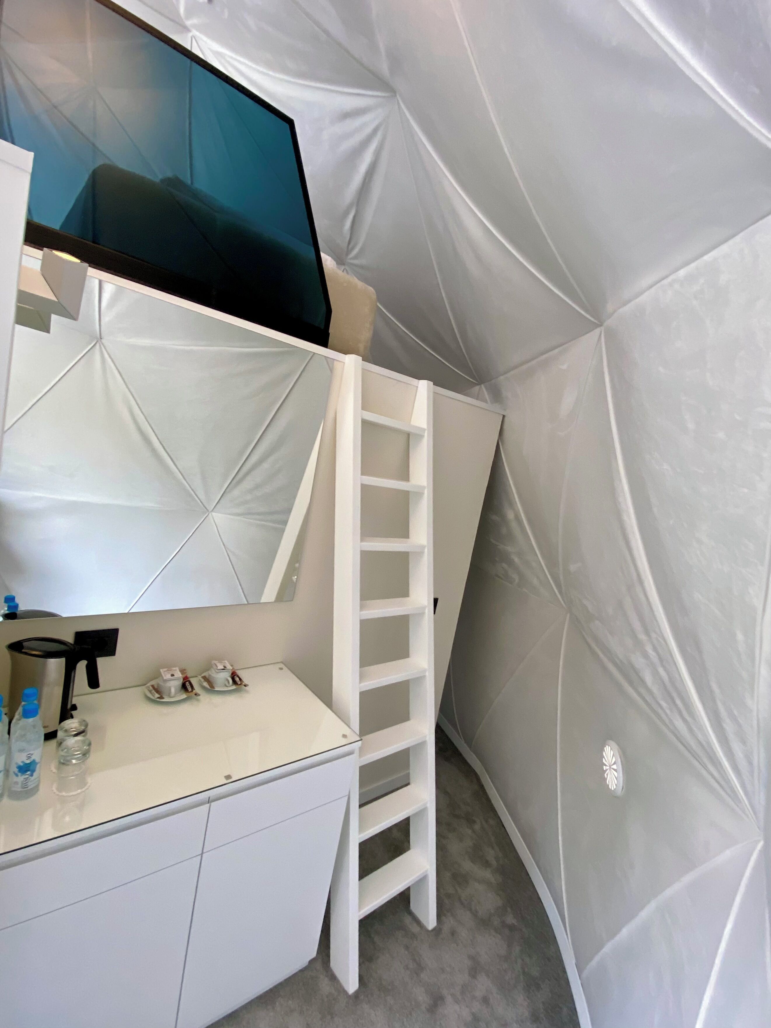A modern bathroom with a white vanity, a mirror, and a built-in shelf.