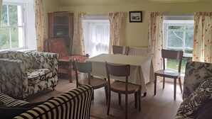 Un salon chaleureux avec une table à manger, des chaises et un canapé.
