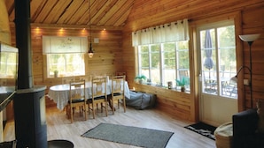 A wooden cabin with a dining area, a fireplace, and large windows. - Awesome Home in Huskvarna With 3 Bedrooms, Jacuzzi and Wifi (Huskvarna)