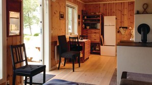 A cozy wooden cabin interior with a dining area, kitchen, and a large window. - Stunning Home in Seim With 2 Bedrooms and Wifi (Alver)