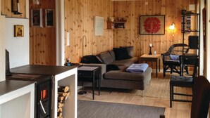 A cozy living room with a fireplace, a sofa, a coffee table, and a bookshelf. - Stunning Home in Seim With 2 Bedrooms and Wifi (Alver)