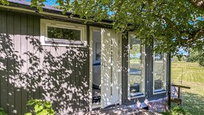 Eine Holzhütte mit Veranda, einer Tür und einem Fenster.