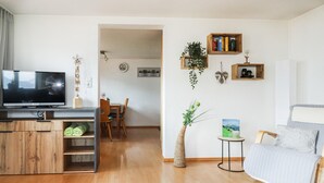 A living room with a TV, wooden furniture, a bookshelf, and a plant. - Amazing Apartment in Uderns With 2 Bedrooms and Wifi (Uderns)
